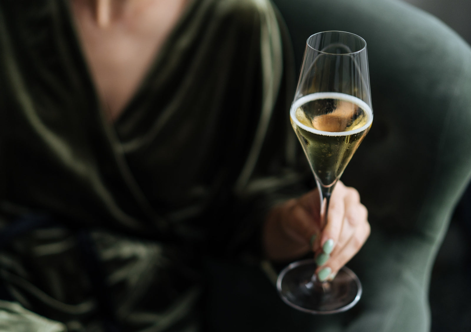 Person holding a glass of Champagne.