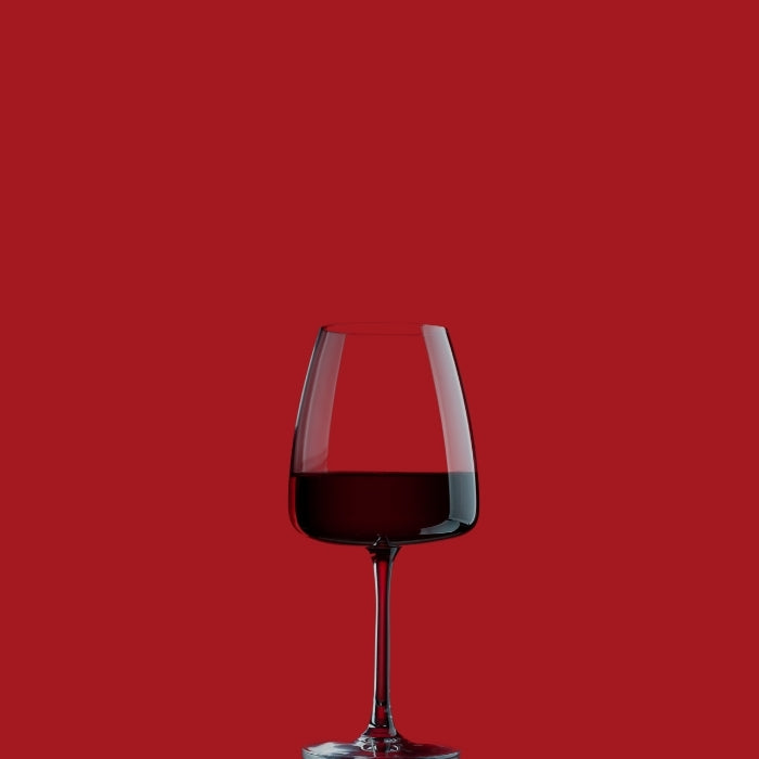 A glass of red wine on a red background illustrating the promotions collection by Whelehans Wines.