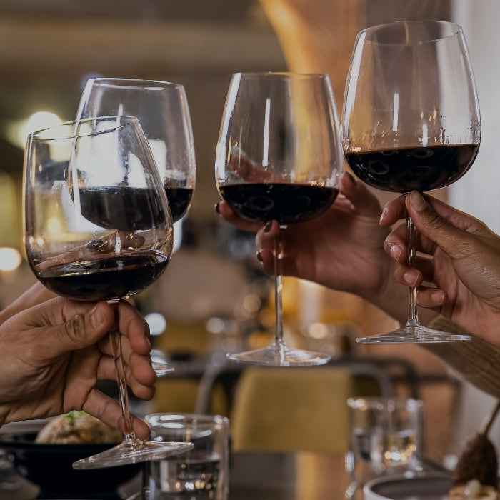 People cheering with a glass of red wine that illustrates the new arrivals section by Whelehans Wines.